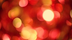 Beautiful vivid multicolor red and gold holiday background of defocused shiny decorations isolated on black backdrop. Christmas, xmas, new year party celebration time.