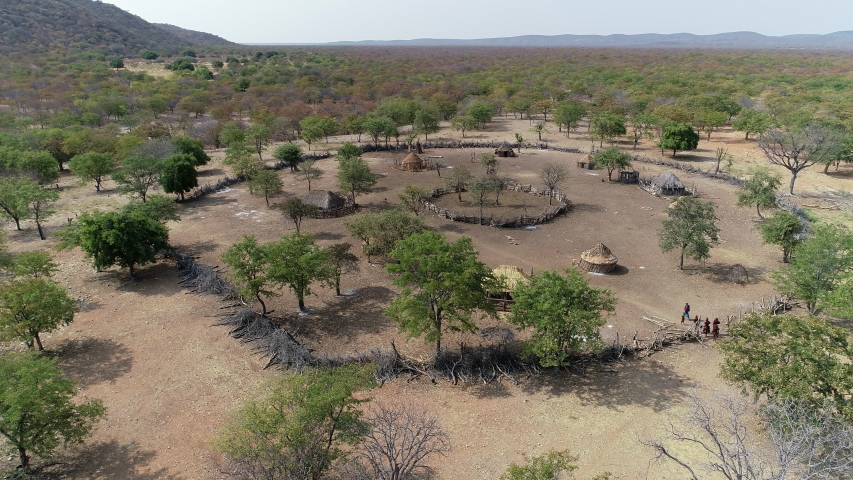 Drone shot-People walk into Ovahimba village