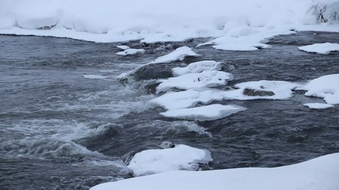 River in winter with snow. The river at dawn. Evaporation from water. Frosty winter. The water did not freeze in winter.