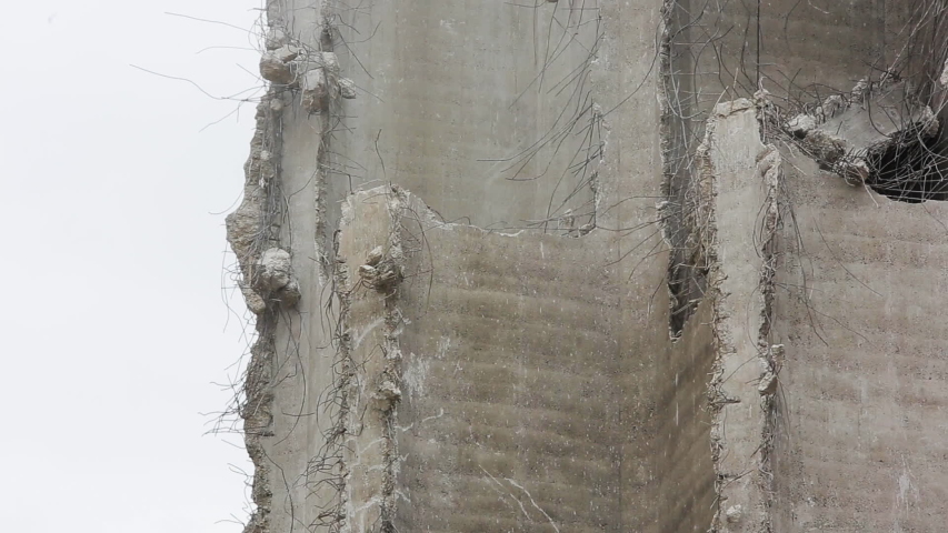 Wrecking ball smashing into ruined building wall. Medium shot.