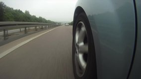A highly stylized clip of a car speeding down the highway on the German autobahn. Highway wheel ungrade.d