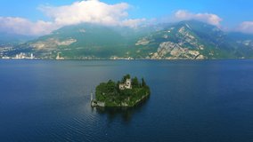Aerial video with drone. The beautiful island of Loreto on Lake Isola, Italy.