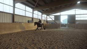 Slow motion shot of a woman riding a horse in riding stablev