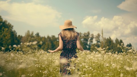 Female Having Fun In Vacation Holiday Trip On Countryside. Lady In Hat Relaxing On Daisy Meadow. Chamomile Flowers Field. Woman Hand Touching Flower And Grass. Happy Girl Enjoying In Green Grass Field