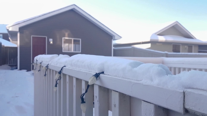 Girl wiping freshsnow from railing cap
