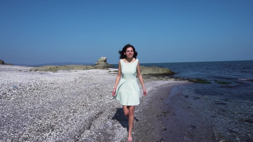 Pretty girl in white dress walk on the beach - 59.94fps