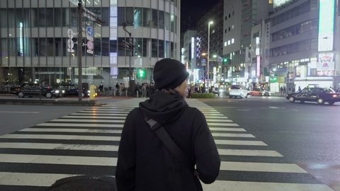 Following a man from behind seeing People crossing Shinjuku street at night time, Shinjuku, Tokyo Japan, October 2018.