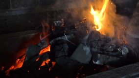 A bright fire burns in the stone oven. The furnace is made of blocks. Burning dark coals. Video in 4K.