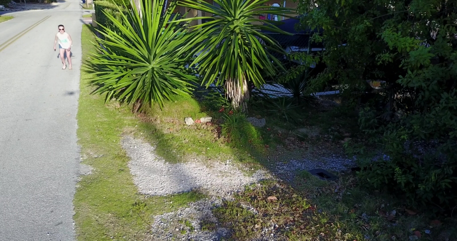 Panning as a girl runs into a path through the mangroves in Key Largo, Florida on a bright and sunny day.
