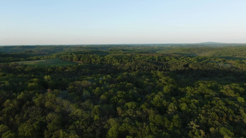 Down moving aerial tilt over a thick forest at a campground in Wisconsin, USA.