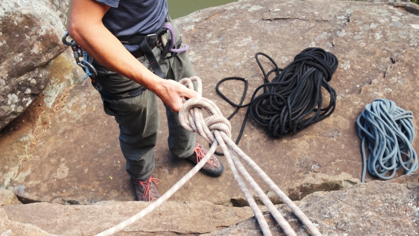 Climber makes a safety knot to climb the steep wall. Mount Wellington , Australia.