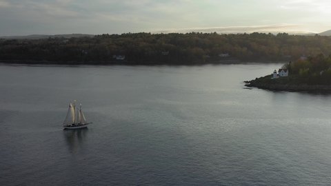 Flying around a schooner sailing around the Curtis Island Lighthouse AERIAL