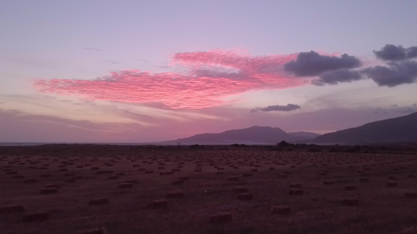 Aerial shot of coast Gibraltar revealing cliffs and beach at beautiful pink sunset