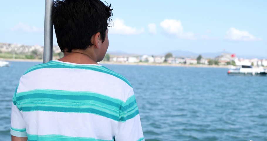 Portrait of a teenager traveler  looking around on yacht deck at summer vacation