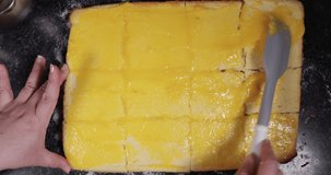 Reverse Clip Of Woman Spreading Egg Crème Around Plain Cake To Then Shape It Into Triangles In Order To Make Portuguese Dessert 4K 30FPS - Sugar, Black Background, Pan