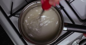 Reverse Clip Of Lady Mixing Water And Sugar In A Pan To Make Caramel 4K 30FPS - Cooking, Boiling, Sweet