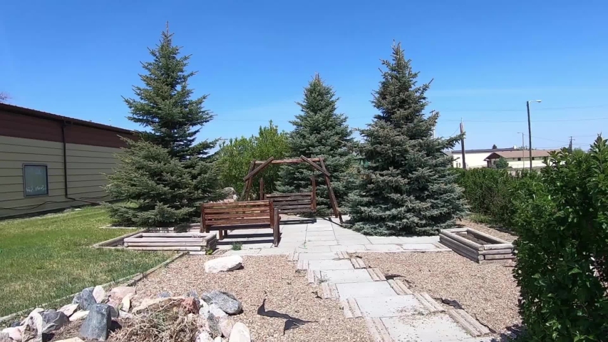 Small park is Empress Alberta Canada with a wooden swing set in the gathering area.