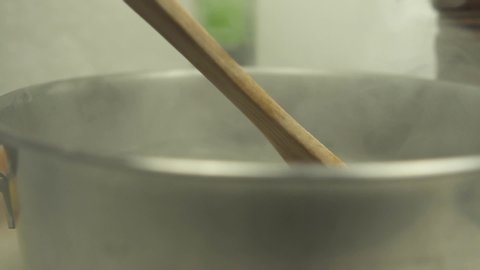 SLOWMOTION: In the kitchen spoon turns water into a boiling pot