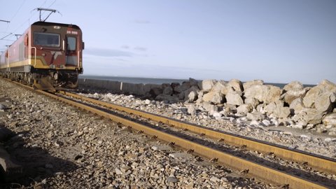 Locomotive engine on rail line pulls a long line of ore carriages past camera in the Eastern Cape of South Africa.