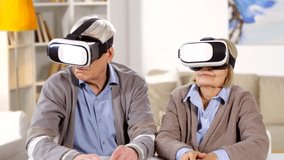 Medium shot of two seniors sitting together at table in VR glasses then taking them off and starting talking