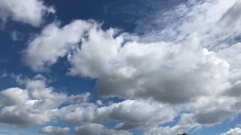 Time lapse, Motion movement with white fluffy, clouds cumulus cloudscape, scenic sunlight, climate on clear blue sky. Ant's view. Natural background.
