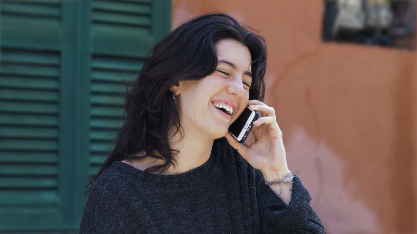 Happy smiling pretty young woman talking by phone.oudoor. Communication, devices