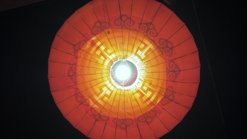 Close-up of a red round lantern with a light bulb inside and yellow fringe swaying in the wind. All-round video from the bottom up. Macau | Shutterstock HD Video #1031460698