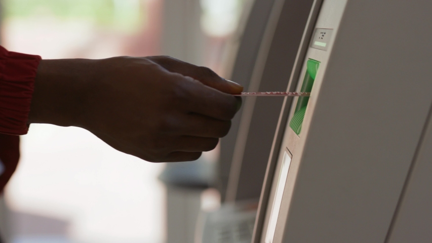 Close-up of african american black man's hand removing a credit card from a cash dispenser. Young man using an ATM machine inside the bank. | Shutterstock HD Video #1031464847