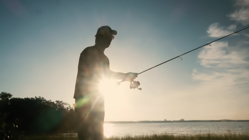 Silhouette of fisherman man casting fishing rod in slow motion  | Shutterstock HD Video #1031480747