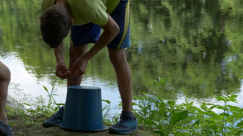 teen child catches a fishing rod on the pond.