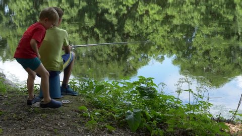 teen child catches a fishing rod on the pond.