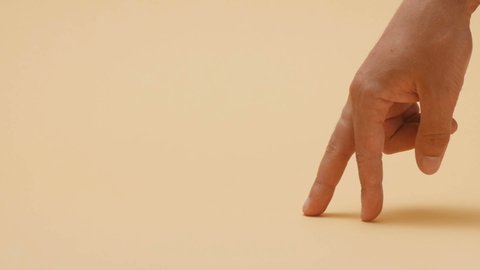 male fingers imitate a person's gait, a person walks on a color cardboard in a studio, a creative idea, movement through life