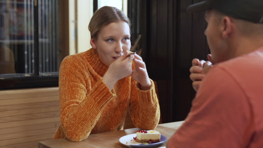 Young couple talking while sitting inside of a cafe