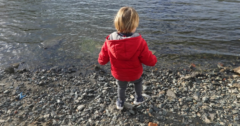boy throws a stone into the water in the spring