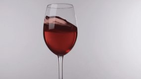 Movement of red wine in a glass standing on a white background, close-up. - Powered by Shutterstock - Get 15% off with code: PIKWIZARD15