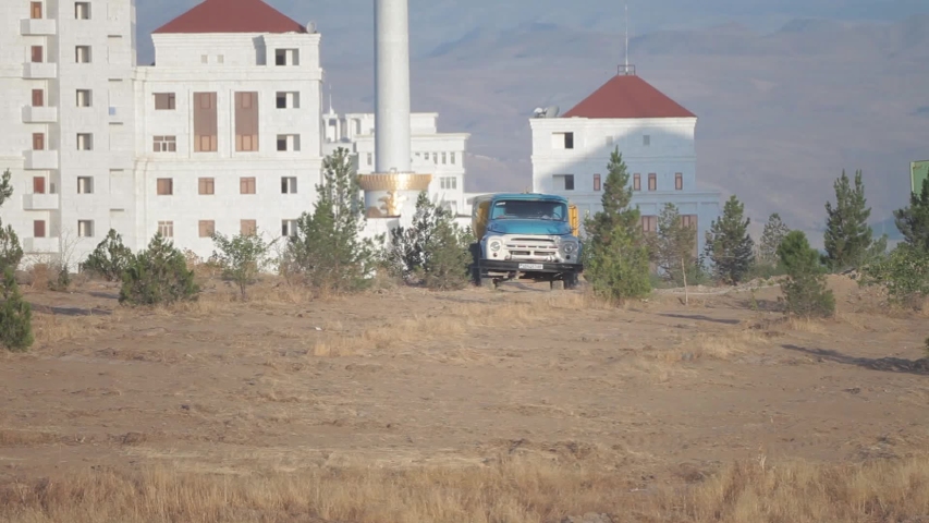 The truck rides on the background of a modern city in Turkmenistan.