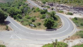 Aerial footage of a mountain road with traffic on a Horseshoe curve.