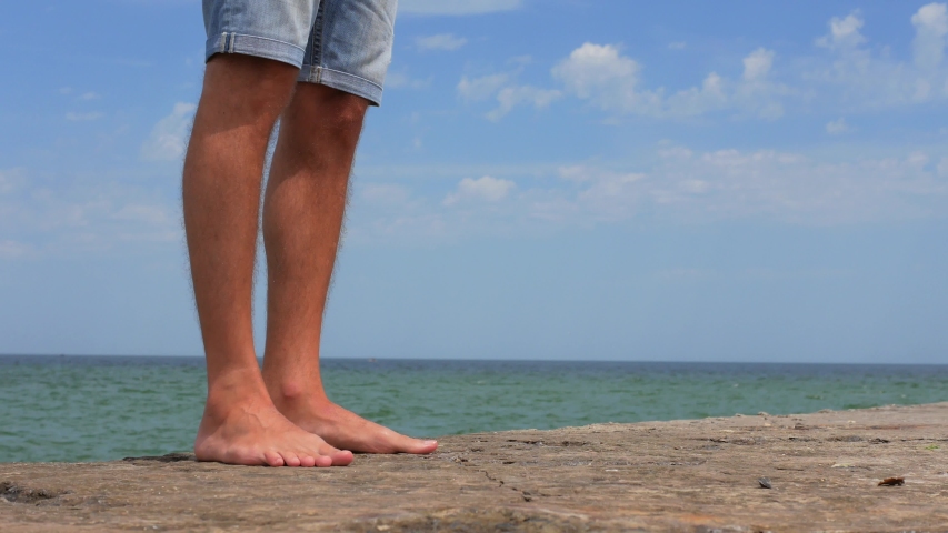 male legs on the pier by the sea, tourist on vacation