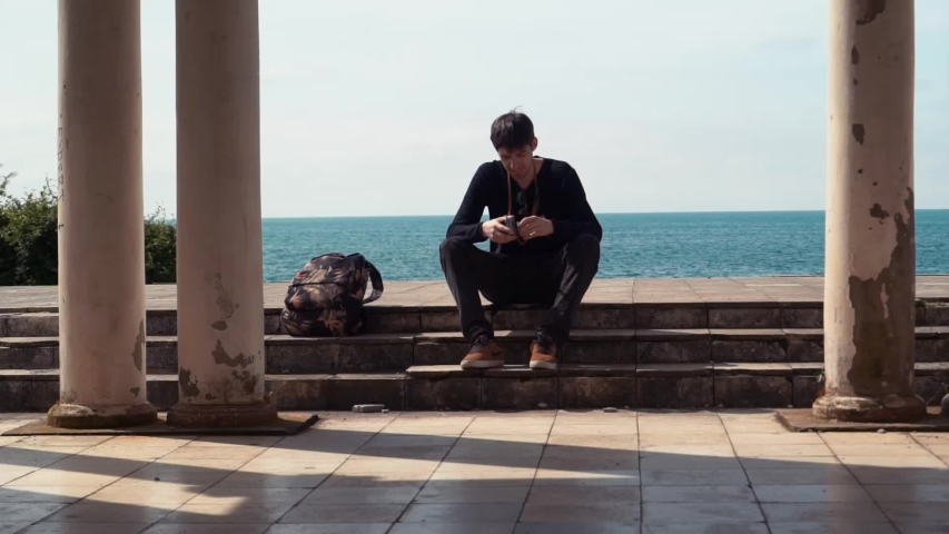 Hipster man cocking the shutter on vintage film dslr camera.
