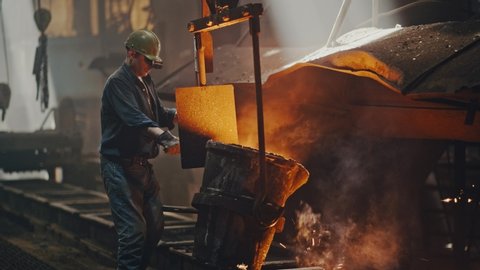 Hard work in the foundry. Pouring molten steel. Liquid steel pouring. Molten metal pouring, metallurgy, steel casting foundry. Steel manufacturing