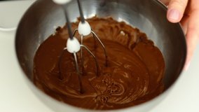 Macro, Slow Motion, Mixer. Whisks whipped chocolate cake dough in the bowl of glass.