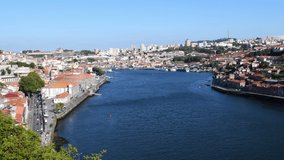 Afternoon view of Douro River with Porto and Vila Nova de Gaia in Portugal. Filmed in mid June. There are boats on the river.