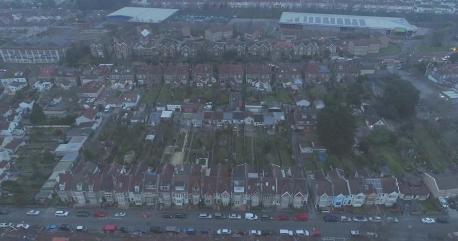 Aerial tilting down over residential houses gardens and garages beside road in South Bristol England Royalty-Free Stock Footage #1031596550