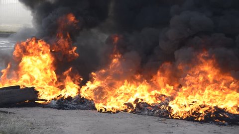 Flames and smoke emanating from tires on fire on the street during a labor strike and protest at Rosario city, Argentina