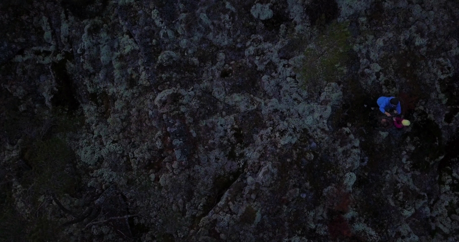 Aerial top down view, drone shot of seniors with grand daughter walking on mountain at dusk, lost in the forest