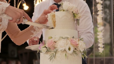 Detail of wedding cake cutting by newlyweds Wedding cake