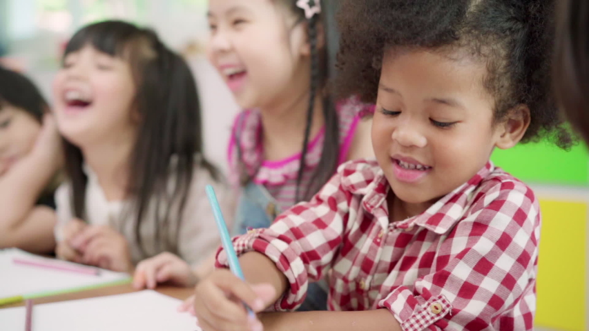 Slow motion - Group of children drawing in classroom, Multi-ethnic young boys and girls happy funny study and play painting on paper at elementary school. Kids drawing and painting at school concept. Royalty-Free Stock Footage #1031619881