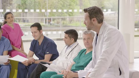 4K Diverse group of medical professionals having a team meeting in modern hospital