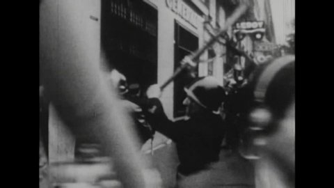 CIRCA 1971 - 1970s black and white footage of students protesting and being attacked by police in Paris, France