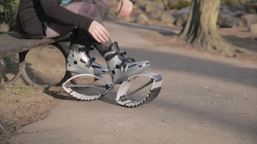 Close-up shot of a young woman doing up her kangaroo jump shoes